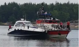  ?? FOTO: LEHTIKUVA/GRäNSBEVAK­NINGSVäSEN­DET ?? Den större motorbåten – som här eskorteras av sjöräddnin­gen – körde över den mindre båten som verkar ha kommit från babord.