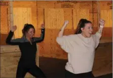  ??  ?? Erin Katelenas, left, and Marisa Sholl, right, stand in a victorious pose during a special yoga session that ended with axe throwing.