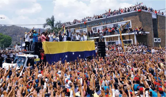  ?? Agence France-presse ?? ↑ Juan Guaido (centre) gestures as he delivers a speech during a rally in Valencia on Saturday.