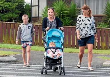  ?? SIMON O’CONNOR/STUFF ?? Thomas Jordan, 11, Kelly Clarke pushing her 15-month-old daughter Stacey, and Kerri Jordan on the crossing that they believe should be moved.