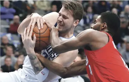  ?? AP ?? Lucha. Luka Doncic, de los Mavericks, y Mo Harkless, de Portland, luchan por el control del balón en acción del partido de ayer en la NBA.