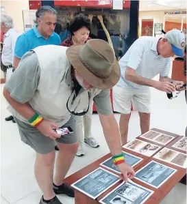  ??  ?? Visitors in The University of the West Indies Museum looking at pictures of scenes from Gibraltar Camp.