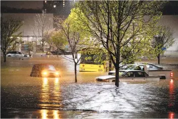  ?? ANDREW NELLES AP ?? Cars sit stranded in a Walmart parking lot on Nolensvill­e Pike in Nashville, Tenn., on Sunday. The area got more than 7 inches of rain in a short time span.