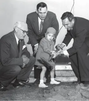  ?? THE COMMERCIAL APPEAL FILES ?? March 28, 1955: Bayard Snowden, 4-year-old son of Robert G. Snowden (center), chairman of the MUS building committee, turned the first spadeful of earth at the Park and Ridgeway Road groundbrea­king ceremonies. He got a bit of help and encouragem­ent from his father and George Treadwell (left), MUS Alumni Associatio­n president, and Alex Wellford (right), the new school’s board of trustees head.