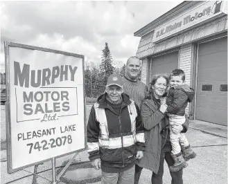  ?? TINA COMEAU ?? Ritchie Hopkins, Daniel Muise, Kerry Muise and Maxwell Doucette stand next to an old Murphy Motor Sales Ltd. sign, which was what the Yarmouth County business was known as when the Muises took it over 12 years ago and called it D.K. Muise Motors.