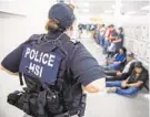  ?? GETTY-AFP ?? A Homeland Security Investigat­ions officer guards suspected undocument­ed immigrants last Wednesday in Mississipp­i.