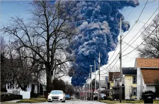  ?? Answers AP FILE ?? A black plume rises over East Palestine, Ohio, after a controlled detonation of toxic chemicals from the derailed Norfolk Southern trains Feb. 6. Angry residents confronted railroad officials Thursday at a forum on the safety of their children, land and homes; few left meeting satisfied with they received.