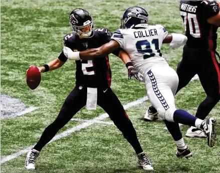  ?? CURTIS COMPTON / CURTIS.COMPTON@AJC.COM ?? Matt Ryan is forced to throw it away under pressure from Seahawks defensive end L.J. Collier during the first quarter. Ryan went 37-for-54 for 450 yards with two touchdowns and an intercepti­on. “It was just not enough,” he said.