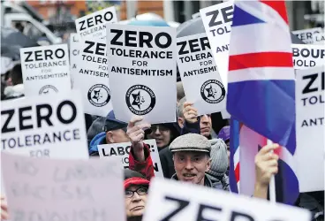  ?? TOLGA AKMEN / AFP / GETTY IMAGES ?? Protesters hold up signs and flags as they gather for a rally organized by the Campaign Against Anti-Semitism outside the head office of Britain’s Labour Party in London earlier this year. British police announced on Friday they are investigat­ing alleged anti-Semitic hate crimes within the party.