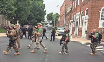  ?? VIRGINIA STATE POLICE VIA EUROPEAN PRESSPHOTO AGENCY ?? Armed men in camouflage clothing and tactical gear march in Charlottes­ville, Va., on Aug. 12. Some militia members say they want to keep the peace, but Virginia’s protest turned violent.
