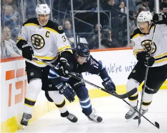  ??  ?? Jets forward Drew Stafford tries to break through the checks of Bruins' defenceman Zdeno Chara, left, and forward Riley Nash during action in Winnipeg on Monday.