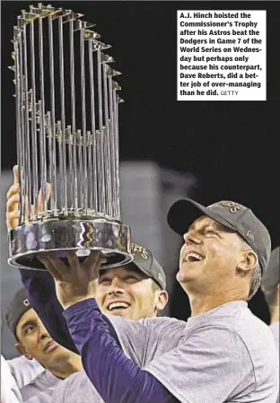  ?? GETTY ?? A.J. Hinch hoisted the Commission­er’s Trophy after his Astros beat the Dodgers in Game 7 of the World Series on Wednesday but perhaps only because his counterpar­t, Dave Roberts, did a better job of over-managing than he did.