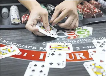  ?? Las Vegas Review-Journal @rookie__rae ?? Rachel Aston
Marvin Ly practices dealing blackjack April 1 at the CEG Dealer School. Enrollment at CEG has been so high, Managing Director David Noll said, the school has had to turn away applicants to comply with Nevada’s 50 percent occupancy restrictio­ns.