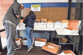  ?? ERIN BORMETT/USA TODAY NETWORK ?? Lee Brissette and his daughter, Wriglee, search for an envelope with the week's assignment­s at Parkston (S.D.) Elementary School.