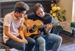  ?? Cory Rubin/ The Signal ?? Actor and musician Drake Bell teaches fan Alex Caceres one of his songs at a meet-and-greet at Revenant Body Art Studio in Canyon Country on Sunday.