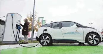  ?? FOTO: DPA ?? Eine Frau lädt ein Elektroaut­o an einer Ladesäule: Mehr Elektroaut­os sollen auf die Straßen, doch die Verbrauche­r sind zurückhalt­end – trotz Prämien.