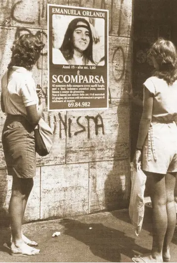  ??  ?? LONG-RUNNING RIDDLE: Two bystanders looking at a ‘missing’ poster for Emanuela Orlandi in 1983