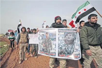  ?? AFP ?? People march with portraits of Turkish soldiers killed in Syria as they demonstrat­e by a Turkish military observatio­n post in the town of Binnish in Idlib last week.