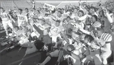  ?? Arkansas Democrat-Gazette/RICK McFARLAND ?? Pine Bluff players celebrate after their victory over Greenwood in the Class 6A championsh­ip game Saturday afternoon at War Memorial Stadium in Little Rock. It was the second consecutiv­e title for the Zebras and Coach Bobby Bolding (bottom, center).