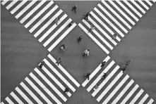  ?? [ASSOCIATED PRESS FILE PHOTO] ?? People wearing protective masks to help curb the spread of the coronaviru­s walk along pedestrian crossings Jan. 8 in the Ginza shipping area of Tokyo.