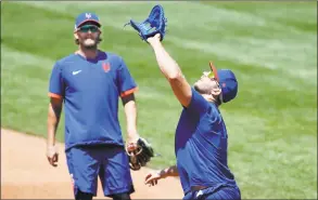  ?? Kathy Willens / Associated Press ?? New York Mets left fielder Jeff McNeil, left, watches as first baseman Pete Alonso waits under a pop fly during fielding drills on Thursday at training camp at Citi Field.