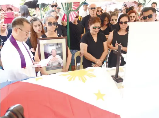  ?? (SUN.STAR FOTO/ALLAN DEFENSOR) ?? FINAL BLESSING. Fr. Randy Figuracion (left) gives the final blessing for Barangay Captain Jose Navarro of Punta Princesa, Cebu City, who was buried at Cebu Evergreen Memorial Garden in Talisay City.