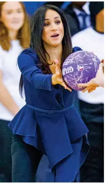  ??  ?? Catch! Meghan, in a blue Oscar de la Renta top, reaches for the ball during the match