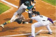  ?? Jack Dempsey / Associated Press ?? The A’s Tony Kemp does a great job of avoiding the tag at home plate by Colorado first baseman Josh Fuentes.