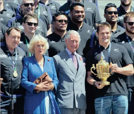  ?? AP ?? ROYAL RECEPTION: Richie McCaw holds the Webb Ellis trophy alongside Prince Charles and the Duchess of Cornwall during a welcome home parade for the world champion All Blacks in Wellington yesterday.