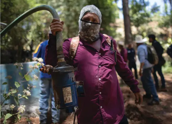  ?? ?? A man shows a pump removed from an unlicensed water intake as his group of residents, farmworker­s and small-scale farmers from Villa Madero dismantle illegal water taps in the mountains of Villa Madero, Mexico, Wednesday, April 17, 2024. As a drought in Mexico drags on, angry subsistenc­e farmers have begun taking direct action on thirsty avocado orchards and berry fields of commercial farms that are drying up streams in the mountains west of Mexico City. (AP Photo/Armando Solis)