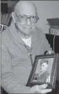  ?? Gwen Albers | New ?? Former New Castle resident Bob Leslie holds a photo of himself from when he served in the Army during World War II. Leslie’s family will host an open house on Saturday at Clen-moore Presbyteri­an Church for his 100th birthday.