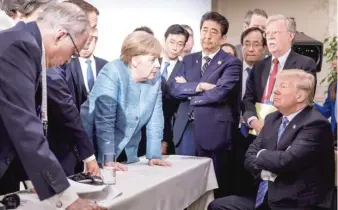  ?? JESCO DENZEL/ GERMAN FEDERAL GOVERNMENT VIA AP ?? German Chancellor Angela Merkel, center, speaks with President Donald Trump during the G- 7 Leaders Summit in La Malbaie, Quebec, Canada, on Saturday.