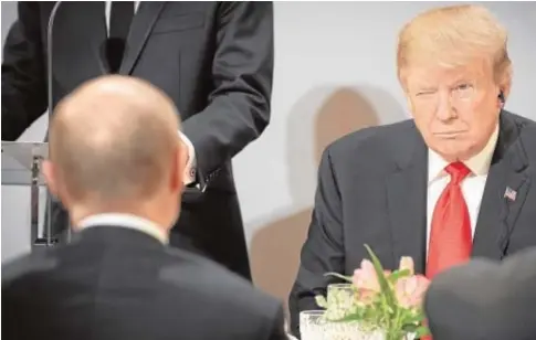  ?? EFE ?? Trump hace un guiño a Putin, sentado enfrente, durante el almuerzo ayer en París