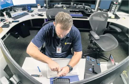  ?? MATIAS J. OCNER mocner@miamiheral­d.com ?? Miami-Dade Police Sgt. Christophe­r George, a member of the South Florida Cyber Crimes Task Force, is seen reassembli­ng a laptop after extracting a hard drive at his desk.