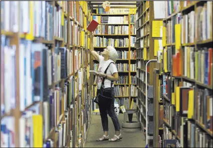  ??  ?? Retired librarian Merilyn Grosshans shops for paperbacks at Amber Unicorn Books in Las Vegas. “It’s very important to have bookstores in our midst,” Grosshans said.