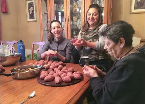  ?? Natalie Lucas ?? Philomina Susa, right, makes stuffed kibbeh, a Middle Eastern dish of ground meat, onion and cracked bulgur wheat, with her granddaugh­ters Natalie Lucas of New Stanton, right, and Dani Susa of Pittsburgh.