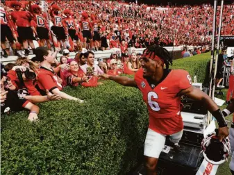  ?? John Bazemore / Associated Press ?? Georgia running back Kenny McIntosh celebrates with fans after defeating Arkansas at home.