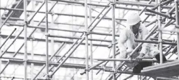  ?? AFP ?? A Filipino worker is seen working on a scaffoldin­g at a constructi­on site in Manila.