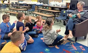  ?? Contribute­d ?? Tina Lee teaches an elementary school class new songs using a donated ukulele.