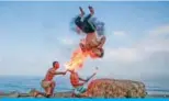  ??  ?? GAZA: Palestinia­n men perform fire breathing on the beach as an entertainm­ent for children during the summer vacation in Gaza City.