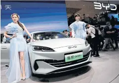  ?? ?? Models stand next to BYD’s Seal 06 DM-i at Auto China 2024 in Beijing on Thursday.