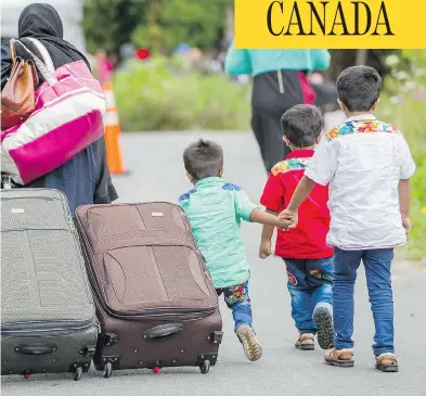  ?? GEOFF ROBINS/AFP/GETTY IMAGES ?? Asylum seekers walk along a road near Champlain, N.Y., this month, making their way toward the Canada-U.S. border.