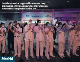  ??  ?? Healthcare workers applaud in return as they are cheered on by people outside the Fundacion Jimenez Diaz hospital in Madrid