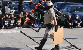  ?? Photograph: David Swanson/Reuters ?? A law enforcemen­t officer removes a menorah placed on the 110 freeway by protesters, in Los Angeles, California, on 13 December 2023.