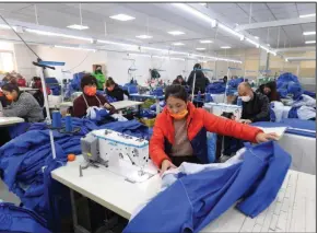  ?? ?? Workers sew fabric Tuesday at a garment factory in Shenyang in northeaste­rn China’s Liaoning province. (AP/Chinatopix)