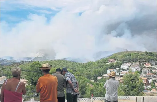  ?? VICENÇ LLURBA ?? Varios vecinos de la urbanizaci­ón El Castell de Montornès, donde comenzó el incendio, mirando cómo avanzaban las llamas