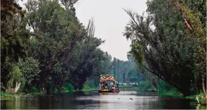  ??  ?? Picture of a boat known as "Trajinera" taken in a water channel amid the floating gardens of Xochimilco, a UNESCO World Heritage Site, during a symposium on biodiversi­ty and gastronomy, in Mexico City. — AFP photos