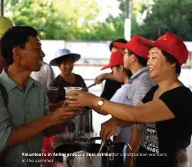  ??  ?? Volunteers in Anhui prepare cool drinks for constructi­on workers in the summer