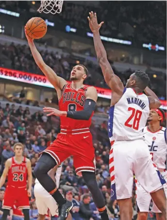  ?? JONATHAN DANIEL/GETTY IMAGES ?? Bulls guard Zach LaVine, who had a game-high 30 points and shot 6-for-11 from three-point range, drives past Wizards center Ian Mahinmi on Wednesday night at the United Center.