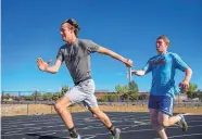  ??  ?? Santa Fe Prep’s Patrick Boyd, left, and Thomas Naylor pass the baton in a relay race during practice Wednesday. Boyd also competes in high jump, the 100-meter dash, and the individual 200- and 400-meter races.